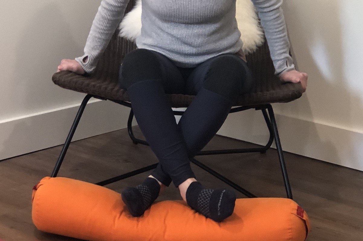 Close up of student sitting on chair, with legs crossed, feet on bolster